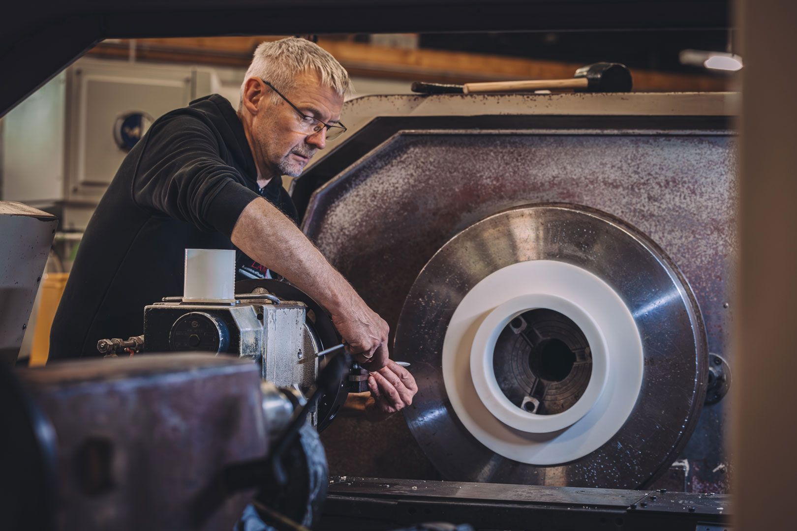 Ein Mann spannt ein Werkzeug in eine CNC-Drehmaschine ein