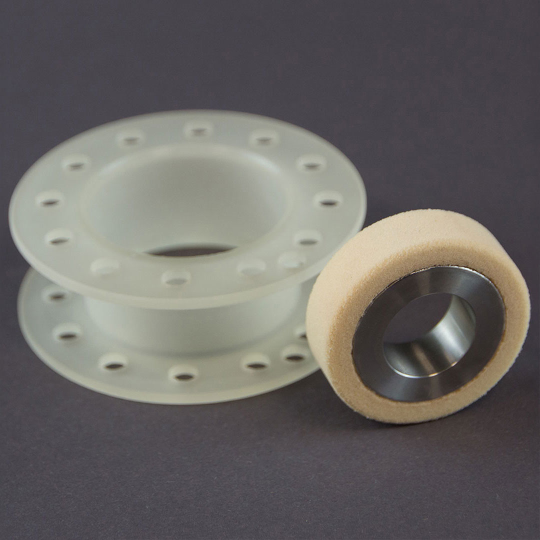 zwei PUR Bauteile Nebeneinander eine Laufrolle mit zelligen PU und ein Drehteil aus kompakten PU