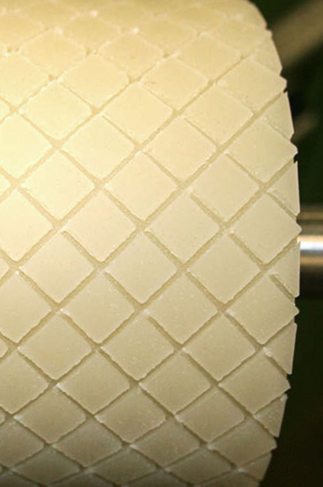 Eine große Rolle aus Polyurethan in der ein Karo-Muster eingefräst ist.