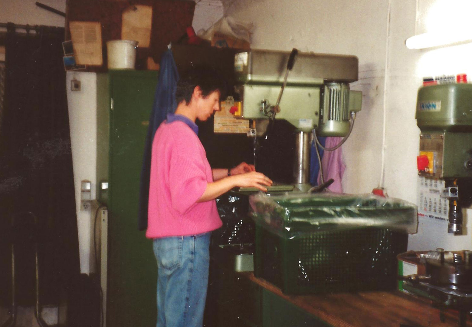 Ein historisches Bild von Monika Lampe an einer Bohrmaschine im ersten kleinen eigenene Firmengebäude