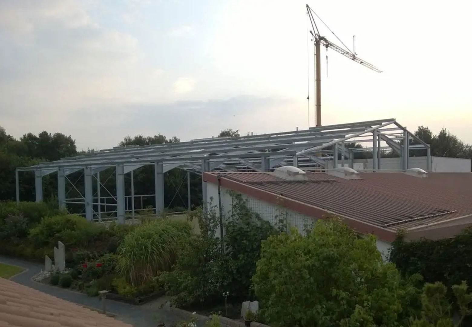 Hinter der alten Produktionshalle der Firma LAMPE Kunststoffbearbeitung steht ein großes Stahlgerüst, die metallernen Grundmauern der neuen Halle.